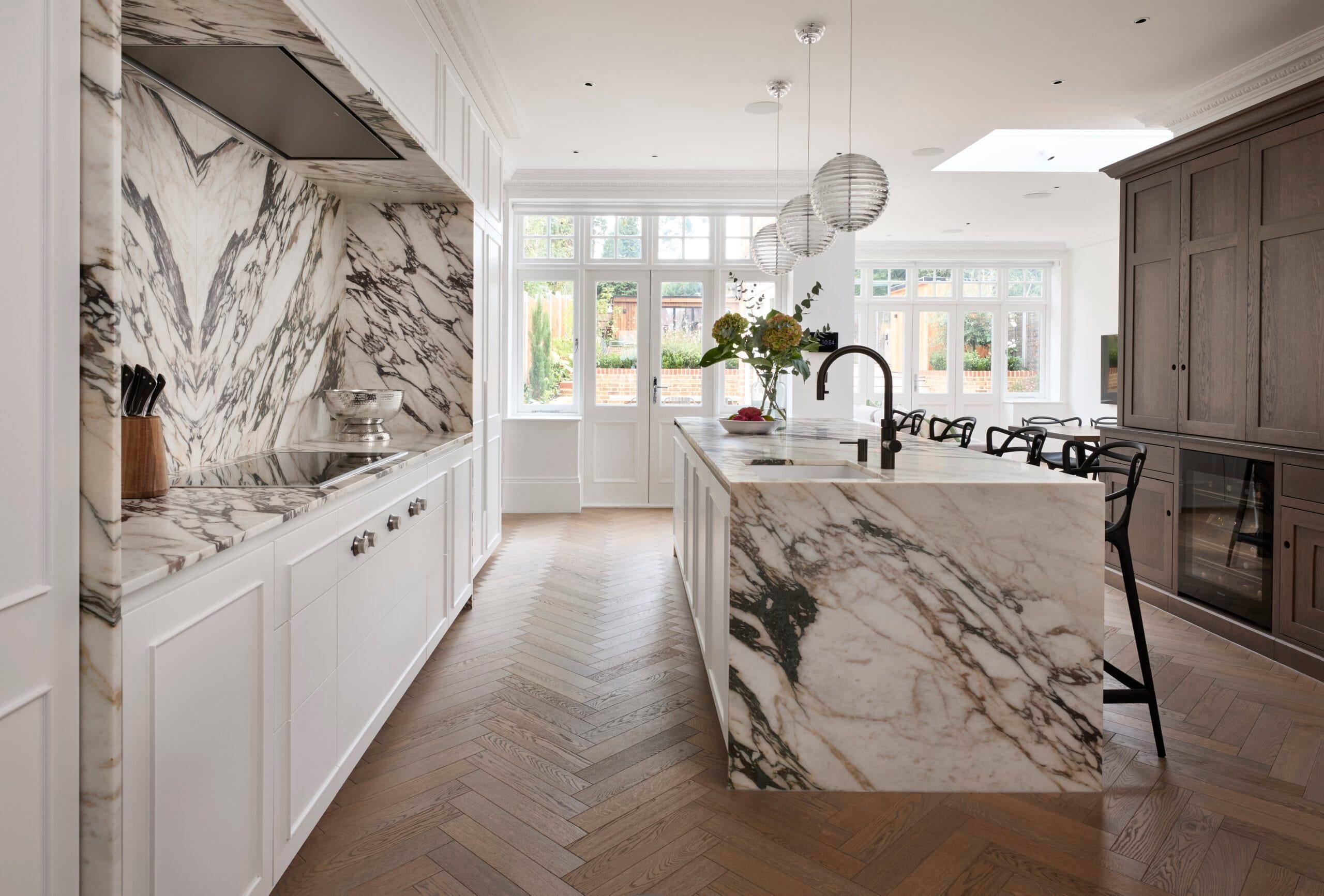 Victoria Road kitchen run towards the garden windows with marble island by En Masse Bespoke